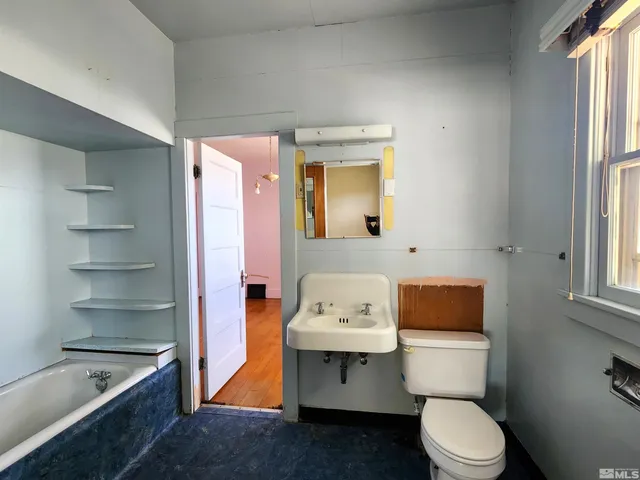 a white toilet sitting next to a bathroom sink