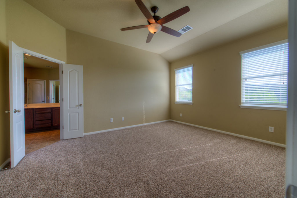 403 Limestone Trail Austin, TX 78737 - Photo 14 of 18 Vast carpeted space with a ceiling fan, dual windows, and an adjacent private bathroom access.