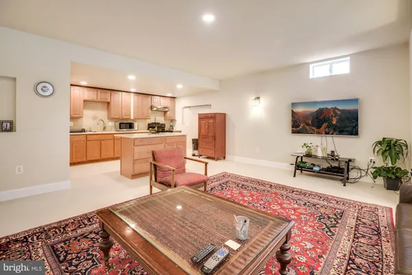 a living room with stainless steel appliances furniture and a rug