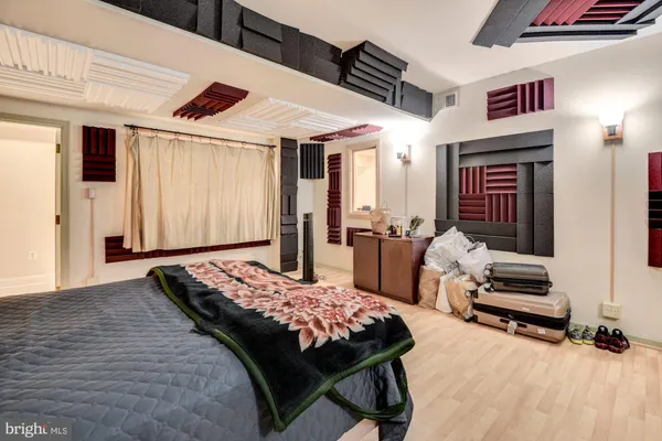 a bedroom with a bed a dresser and potted plants