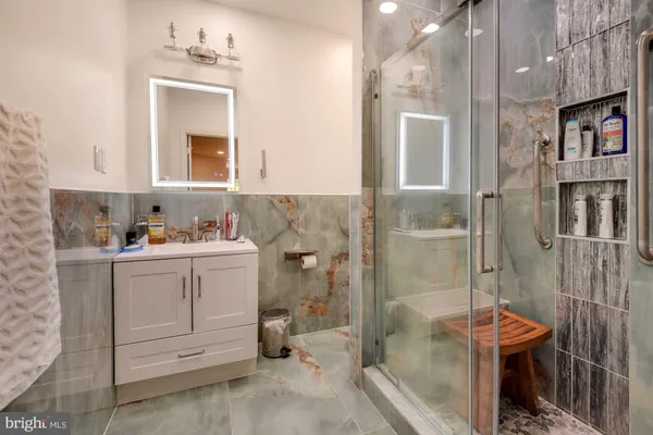 a bathroom with a sink mirror and a shower