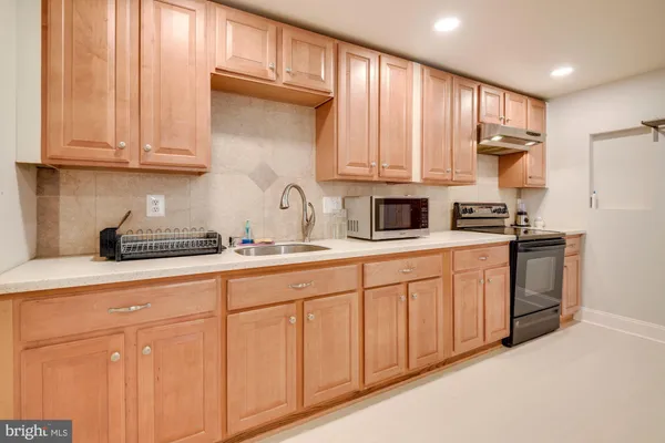 a kitchen with stainless steel appliances granite countertop a sink a stove and cabinets