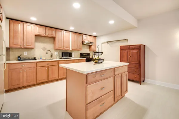a kitchen with a sink wooden cabinets and white appliances