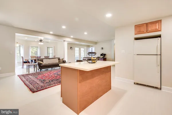a living room with stainless steel appliances kitchen island granite countertop a refrigerator a stove a sink dishwasher with a dining table and chairs