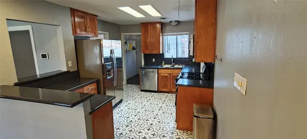 a kitchen with stainless steel appliances granite countertop a refrigerator and a stove