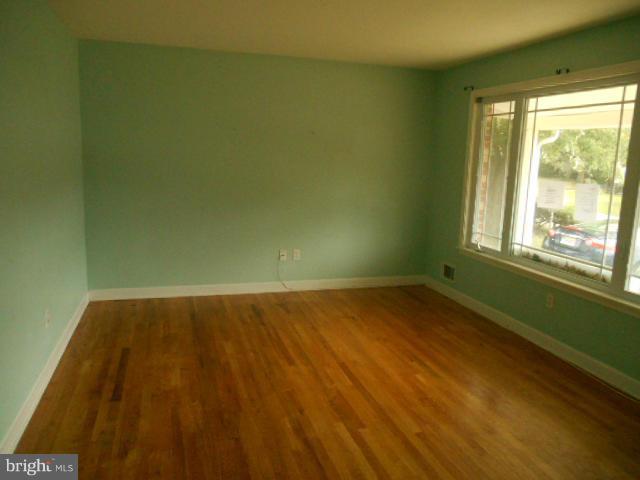 1406 Larch Road Severn, MD 21144 - Photo 2 of 15 a view of an empty room with wooden floor and a window