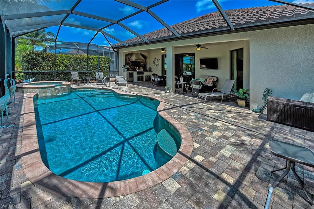 9415 Piacere Way Naples, FL 34113 - Photo 20 of 35 a view of a backyard with table and chairs under an umbrella
