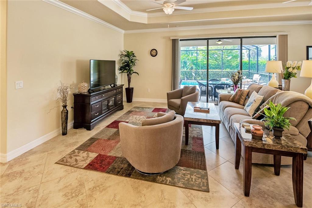 9415 Piacere Way Naples, FL 34113 - Photo 5 of 35 a living room with couches a flat tv screen and a dining table with garden view