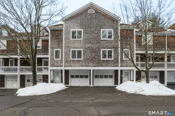 a front view of a building with a yard and parking space