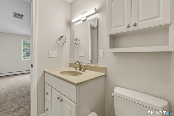 a bathroom with a sink toilet vanity and tub