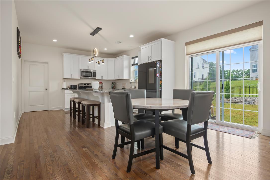 640 Rinaldi Lane Easton, PA 18040 - Photo 14 of 42 Rich hardwood floors complement a well-lit kitchen with a granite island, perfect for casual dining or entertaining.