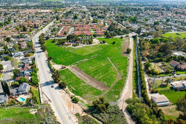an aerial view of residential houses with outdoor space and trees