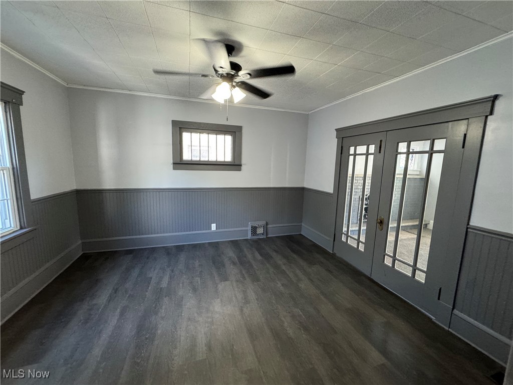 2425 7th Street Northwest Canton, OH 44708 - Photo 7 of 19 Spare room featuring a wainscoted wall, dark wood-style flooring, french doors, crown molding, and ceiling fan