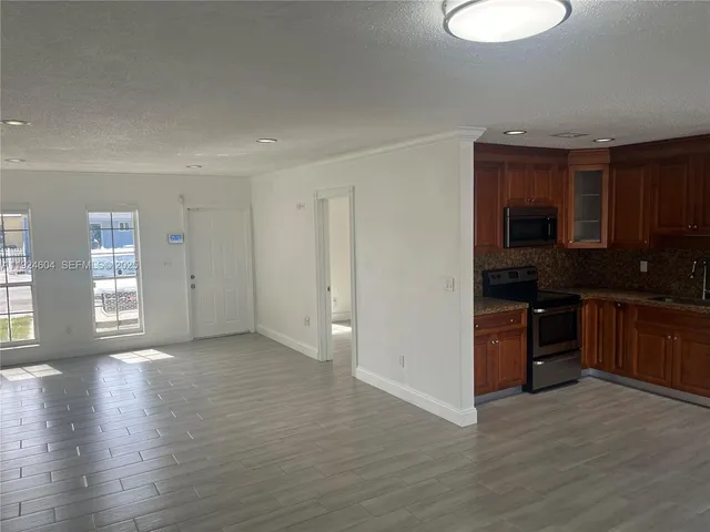 a view of a kitchen with a sink stove and cabinets