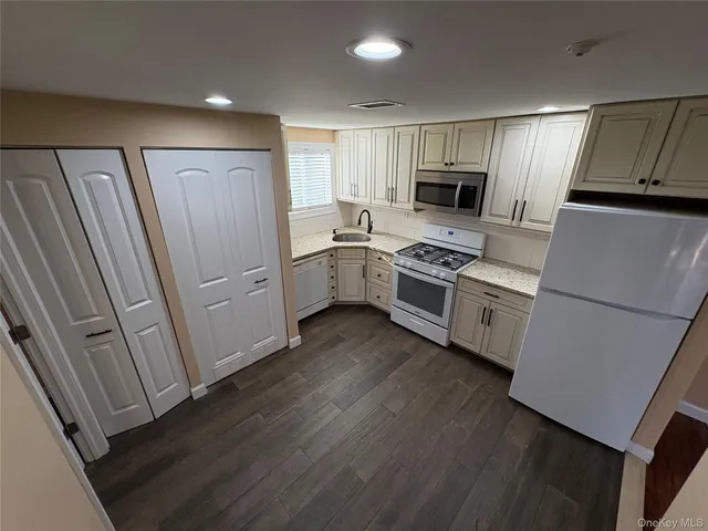 a kitchen with white cabinets and stainless steel appliances
