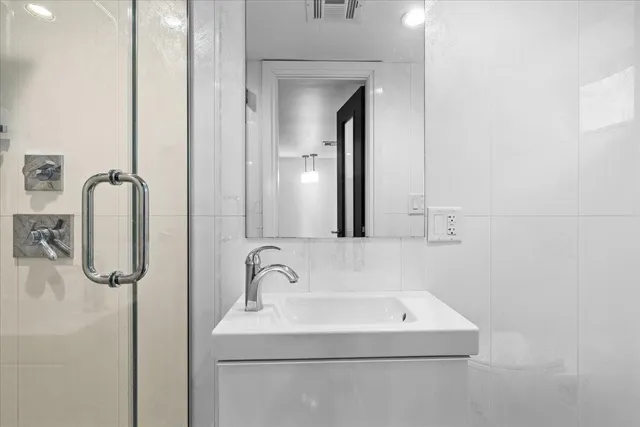 a bathroom with a sink a mirror and shower