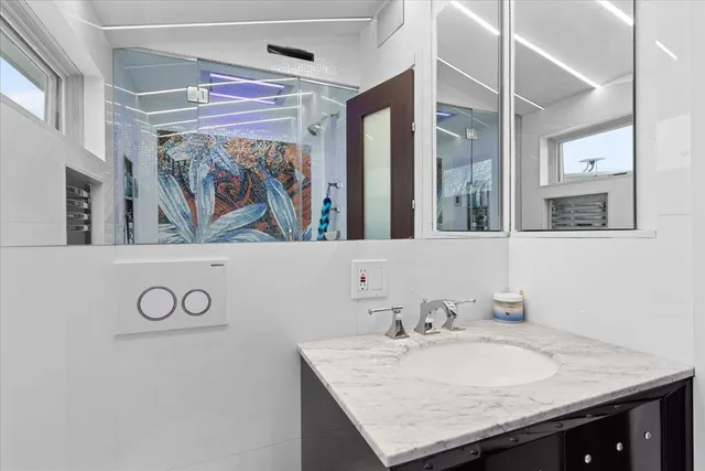 a bathroom with a granite countertop sink and a mirror