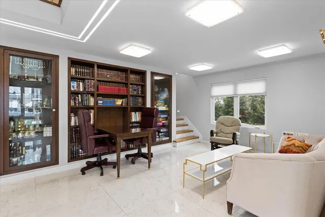 a living room with furniture a bookshelf and a large window