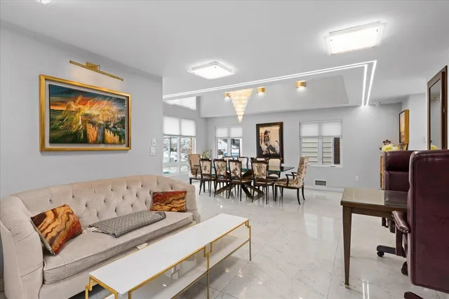 a living room with furniture and a dining table with wooden floor