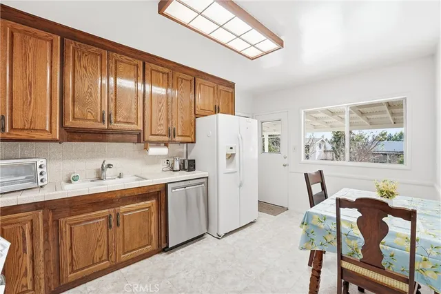 a kitchen with refrigerator cabinets and window