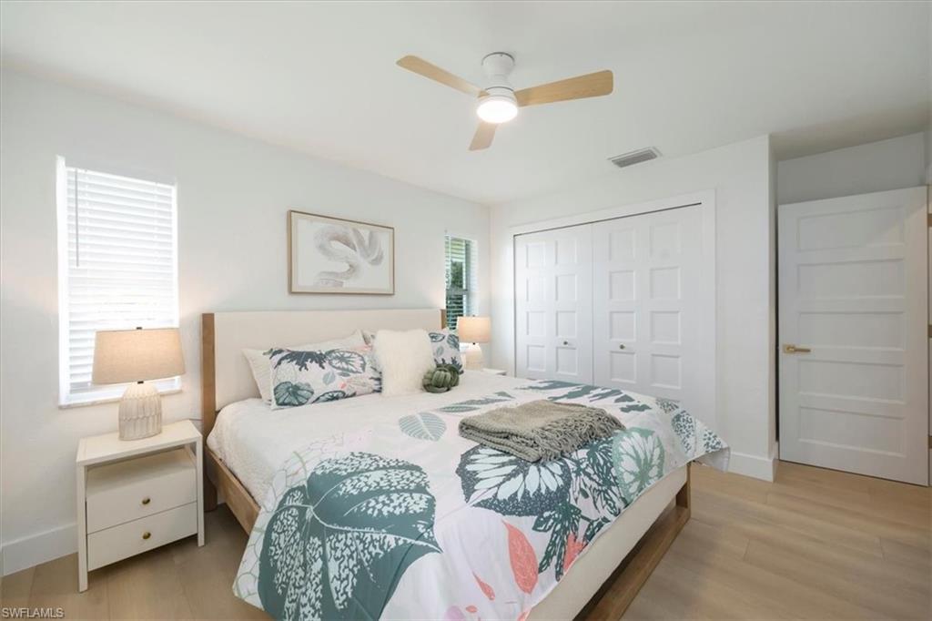 4523 Fluvia Avenue Naples, FL 34103 - Photo 12 of 20 a bedroom with a large bed and a ceiling fan
