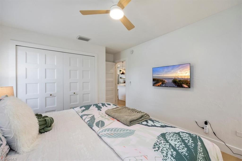 4523 Fluvia Avenue Naples, FL 34103 - Photo 13 of 20 a bedroom with a bed and a chandelier