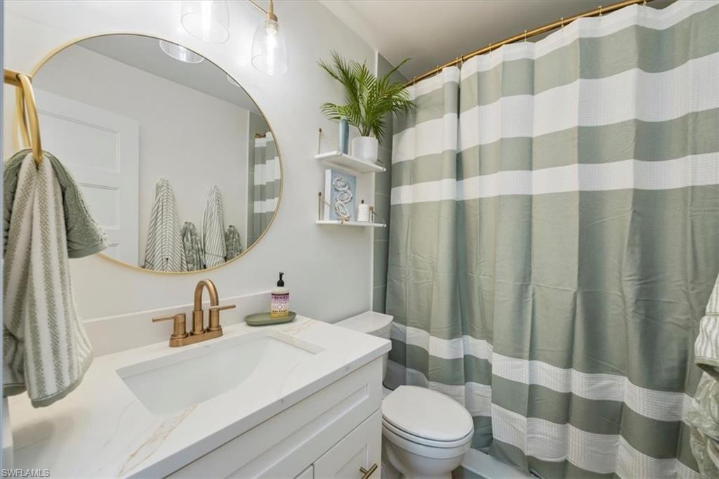 4523 Fluvia Avenue Naples, FL 34103 - Photo 14 of 20 a bathroom with a sink toilet and shower