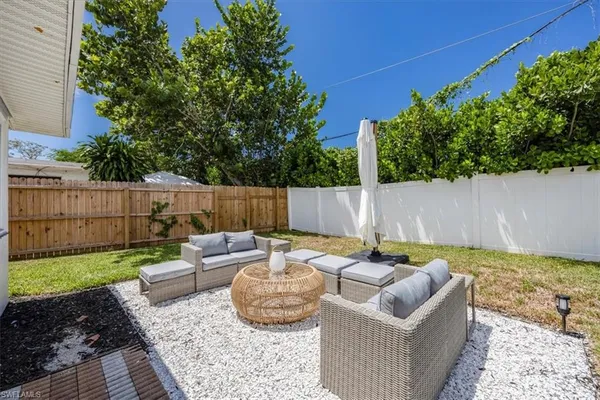 swimming pool with outdoor seating and green bushes