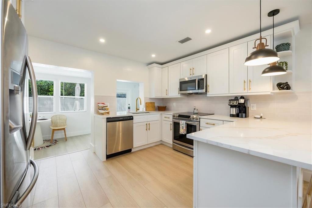 4523 Fluvia Avenue Naples, FL 34103 - Photo 5 of 20 a kitchen with a sink window and stainless steel appliances