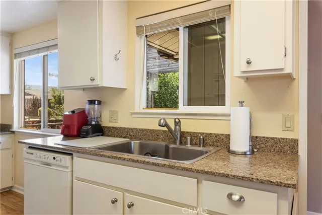 a close view of a refrigerator a sink and dishwasher a cabinets with wooden floor
