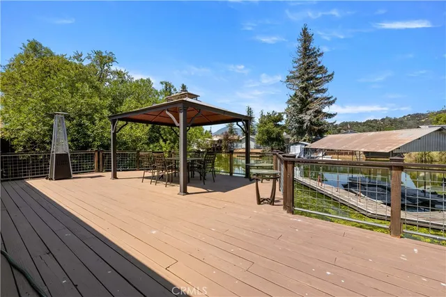 a view of a lake with couches chairs under an umbrella
