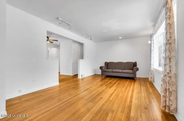 a view of livingroom with kitchen and wooden floor