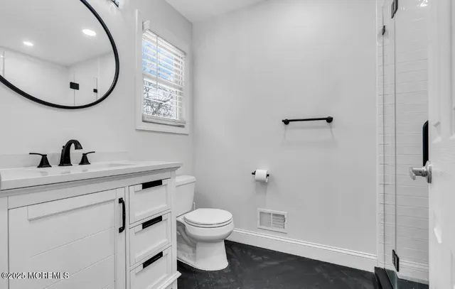 a bathroom with a toilet a sink and mirror