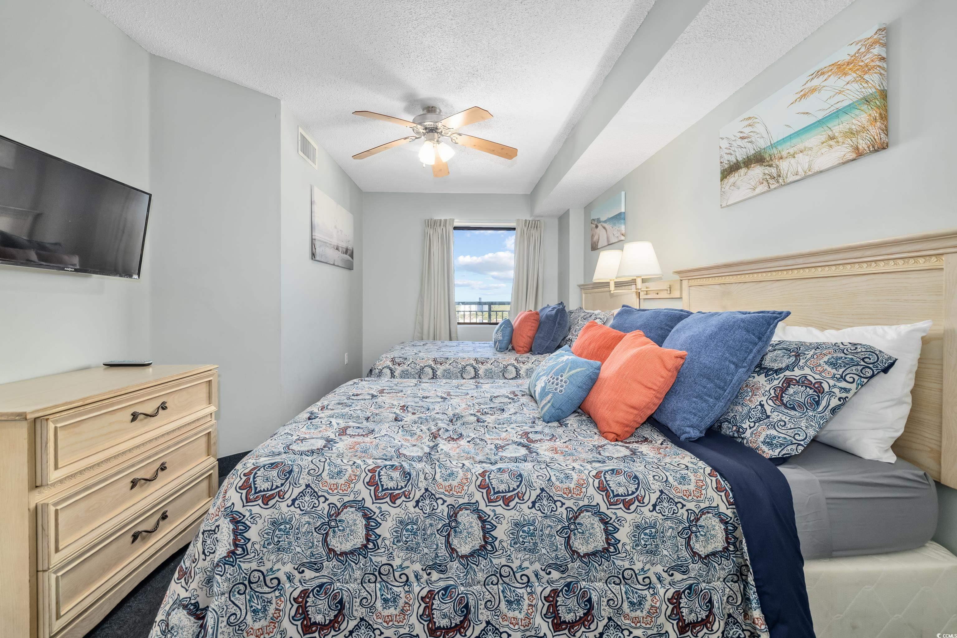 205 74th Avenue North, Unit 1104 Myrtle Beach, SC 29572 - Photo 12 of 40 Bedroom with a ceiling fan and a textured ceiling
