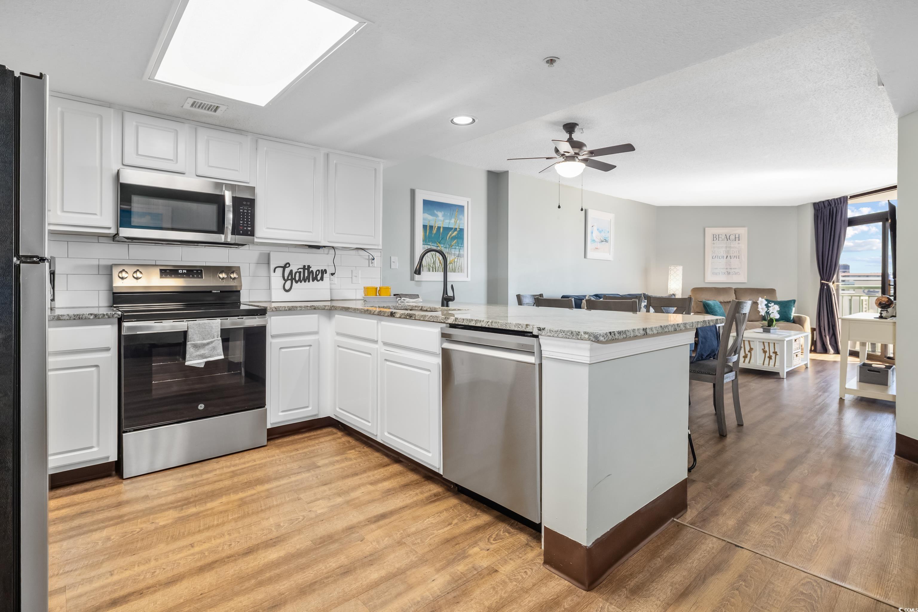 205 74th Avenue North, Unit 1104 Myrtle Beach, SC 29572 - Photo 14 of 40 Kitchen with tasteful backsplash, appliances with stainless steel finishes, white cabinetry, light wood-style floors, and recessed lighting