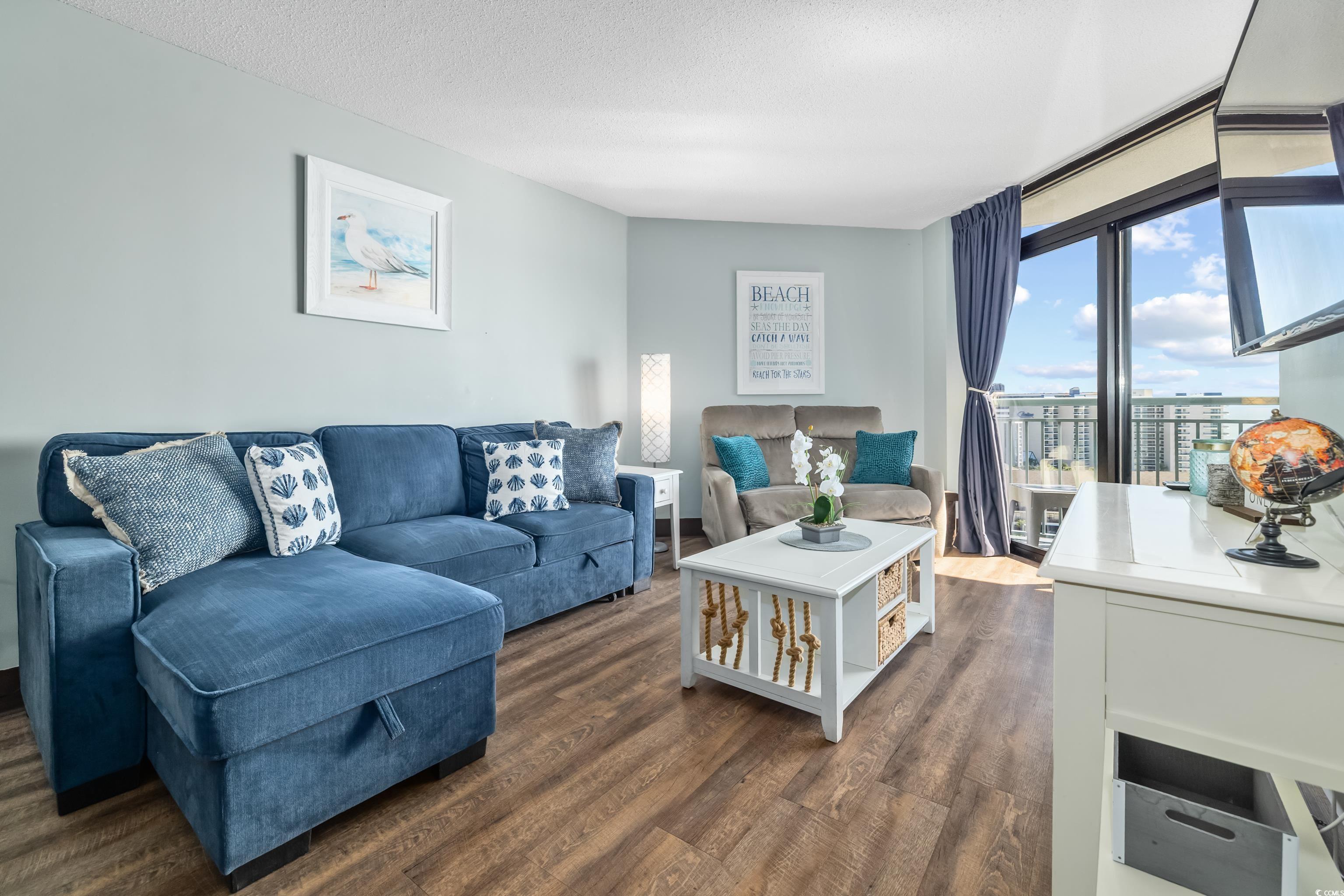 205 74th Avenue North, Unit 1104 Myrtle Beach, SC 29572 - Photo 21 of 40 Living area featuring dark wood-style flooring and a textured ceiling