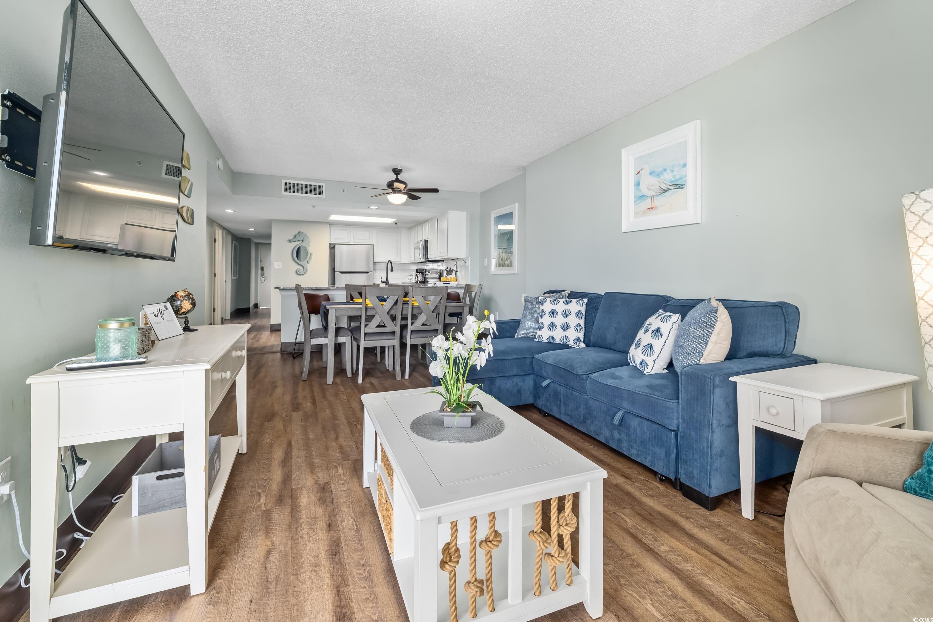 205 74th Avenue North, Unit 1104 Myrtle Beach, SC 29572 - Photo 25 of 40 Living room with dark wood-style floors, a textured ceiling, and a ceiling fan