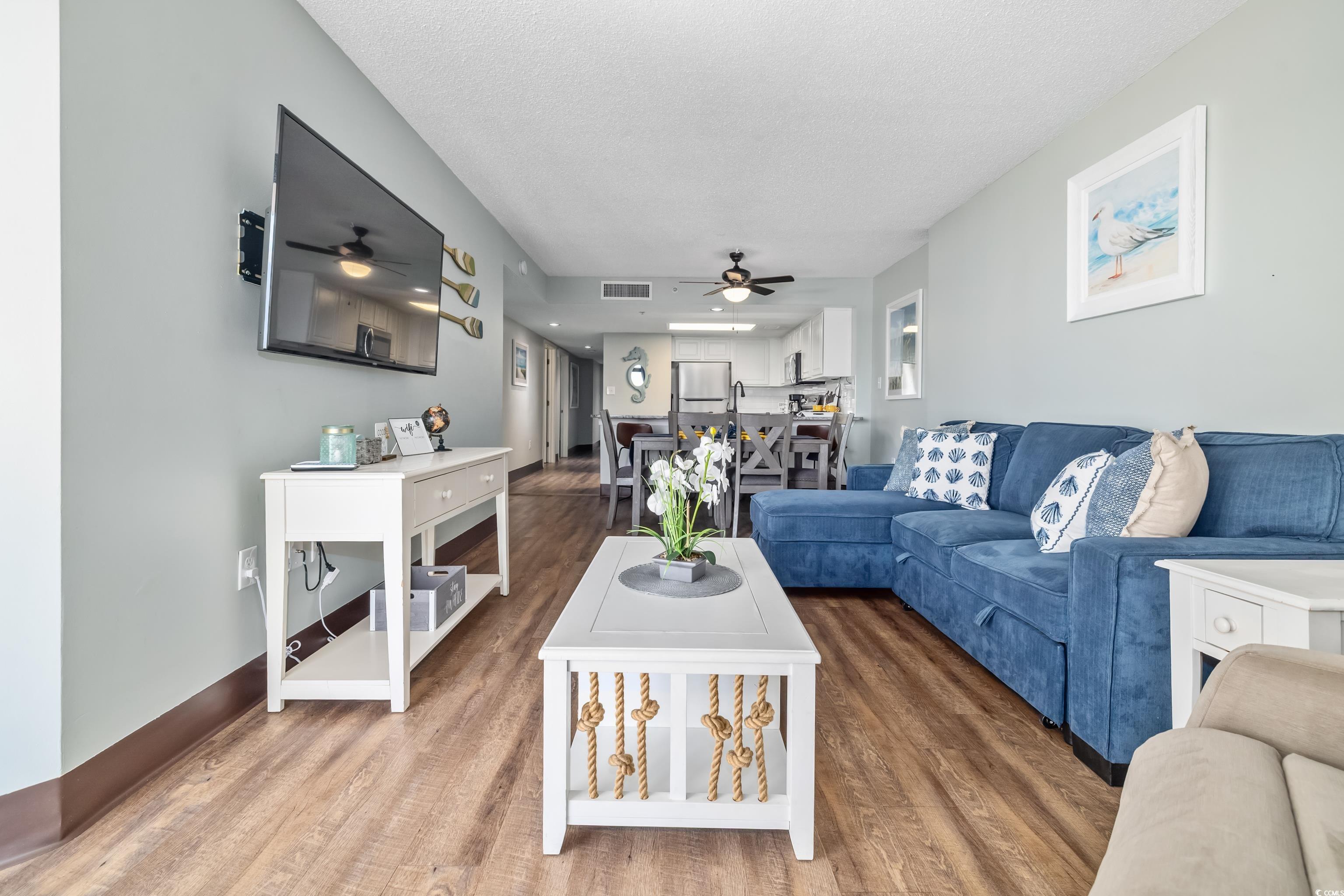205 74th Avenue North, Unit 1104 Myrtle Beach, SC 29572 - Photo 26 of 40 Living room featuring wood finished floors, a textured ceiling, and ceiling fan
