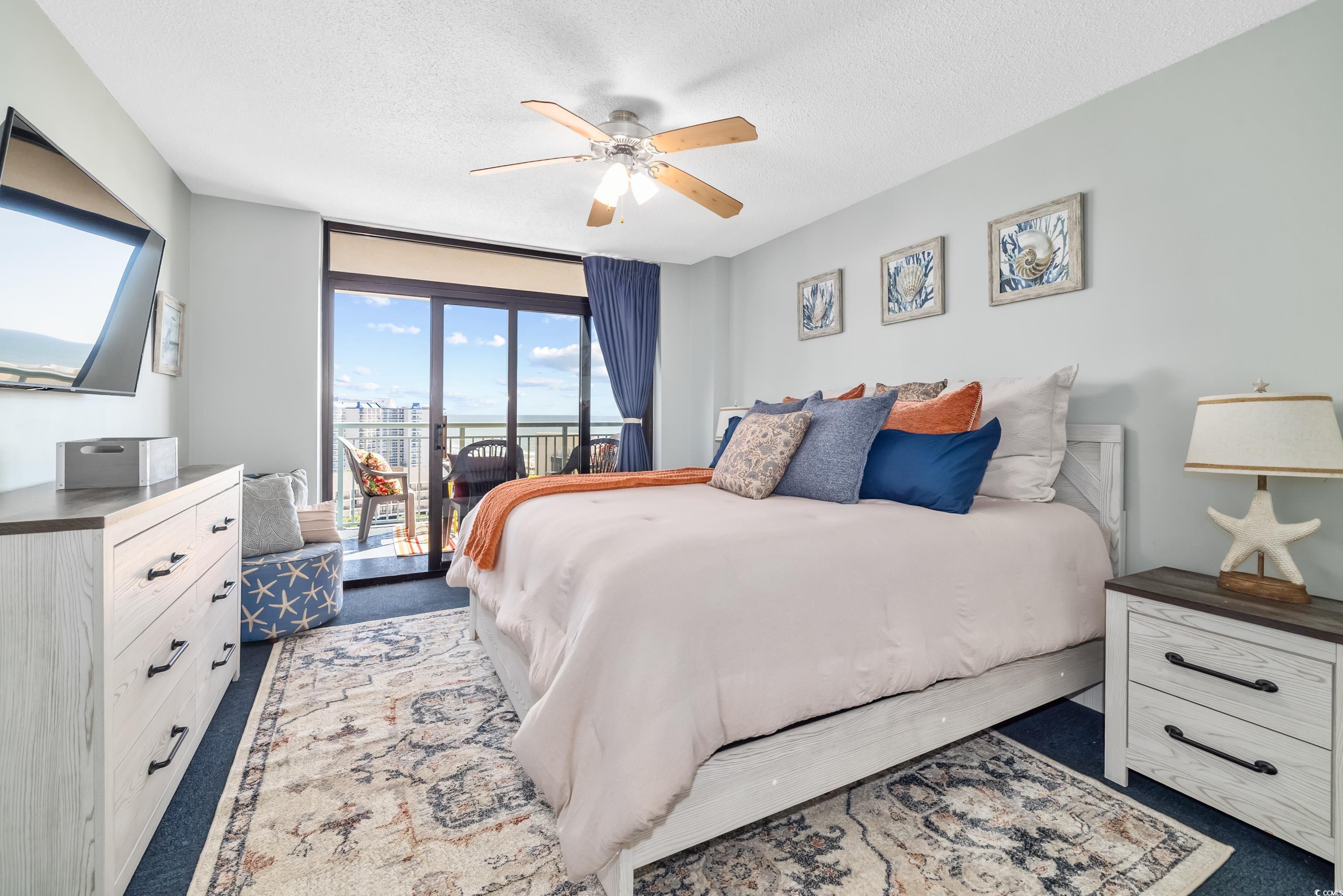 205 74th Avenue North, Unit 1104 Myrtle Beach, SC 29572 - Photo 27 of 40 Bedroom with access to exterior, a textured ceiling, dark colored carpet, and ceiling fan