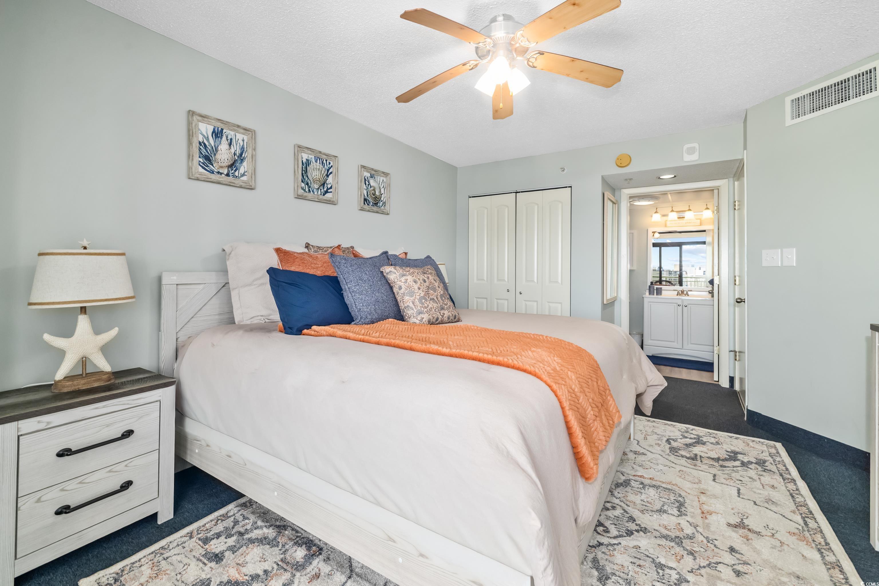 205 74th Avenue North, Unit 1104 Myrtle Beach, SC 29572 - Photo 29 of 40 Bedroom with dark carpet, a closet, ceiling fan, and a textured ceiling