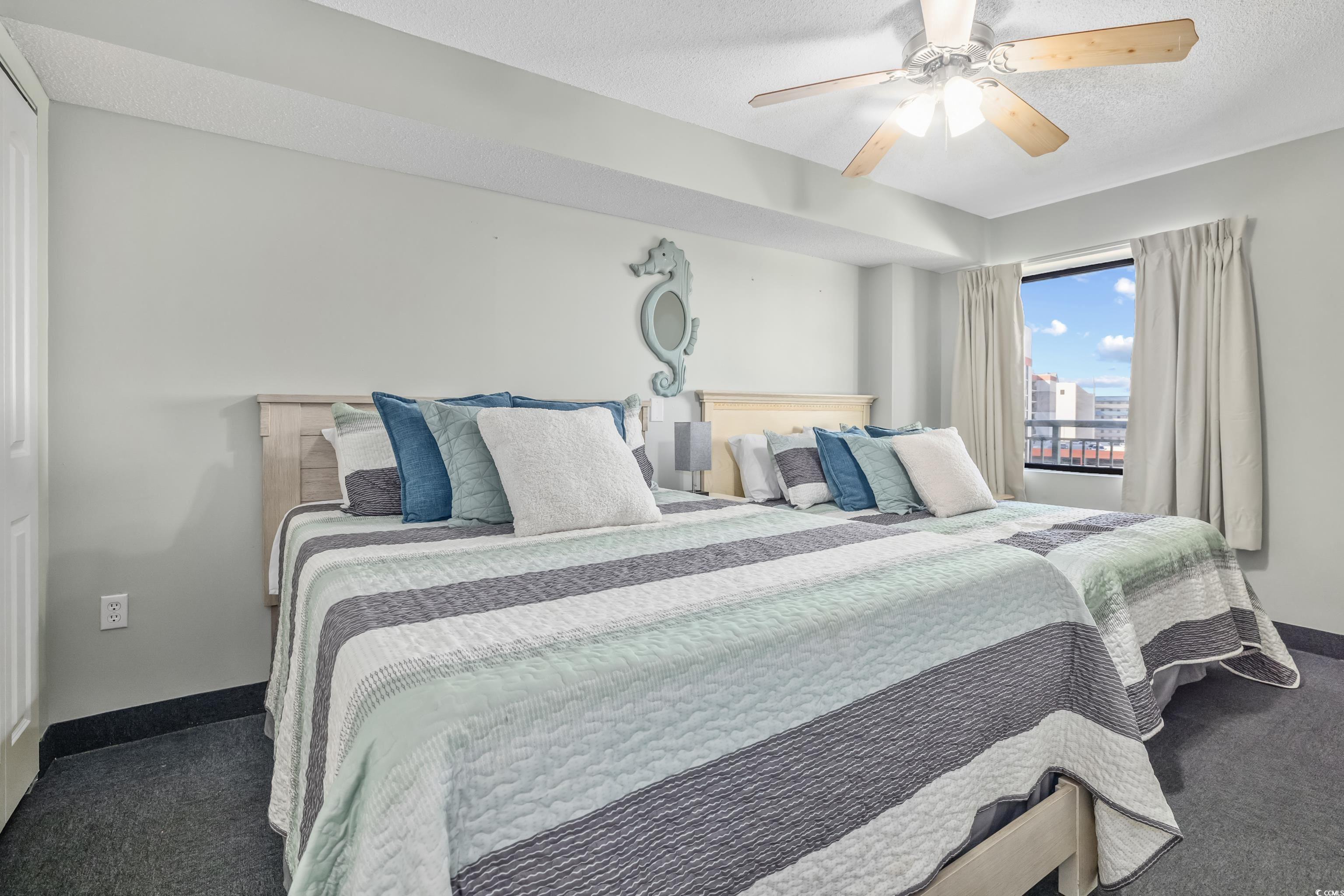 205 74th Avenue North, Unit 1104 Myrtle Beach, SC 29572 - Photo 9 of 40 Bedroom with dark carpet, a textured ceiling, and ceiling fan