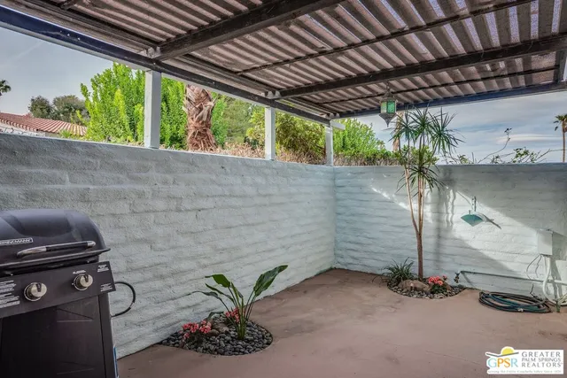 a backyard of a house with a garden and outdoor seating