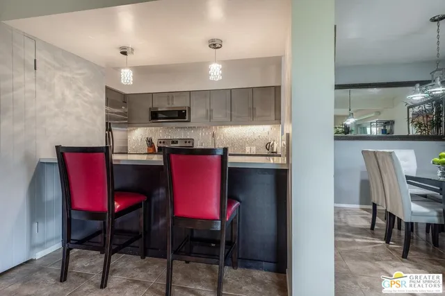 a kitchen with a dining table chairs and refrigerator