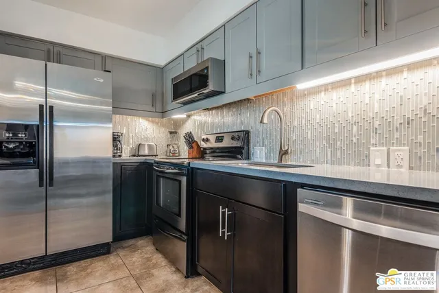 a kitchen with stainless steel appliances granite countertop a refrigerator and a sink
