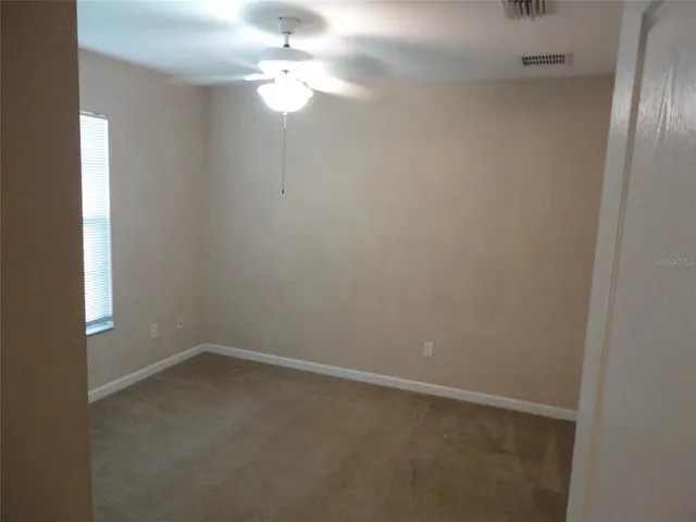 en empty room with windows and fan