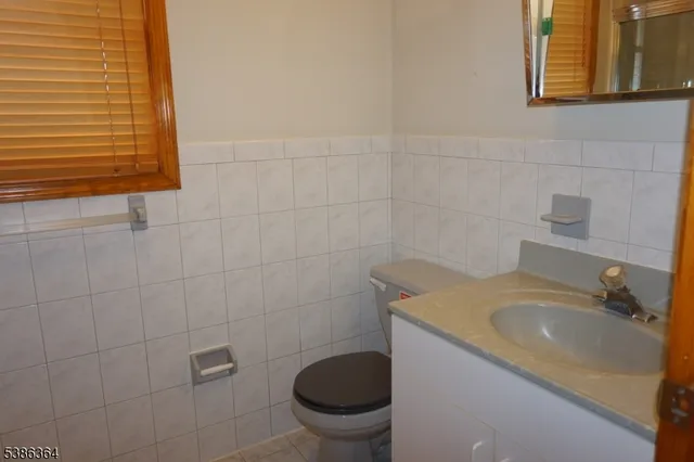 a bathroom with a granite countertop toilet sink and mirror