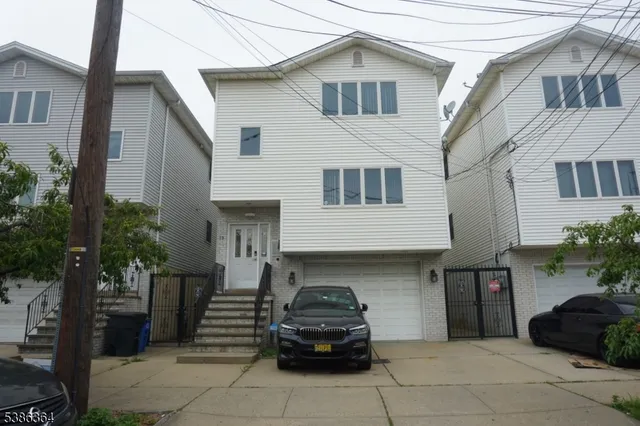 a car parked in front of a white house