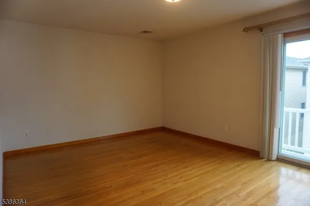 a view of an empty room and wooden floor