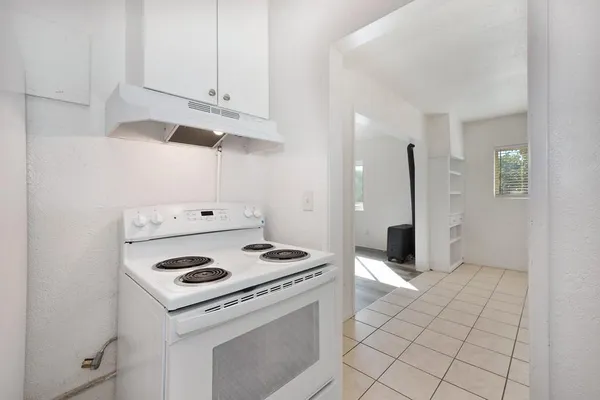 a kitchen with white cabinets and appliances
