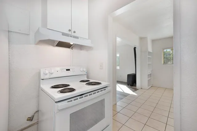 a kitchen with white cabinets and appliances